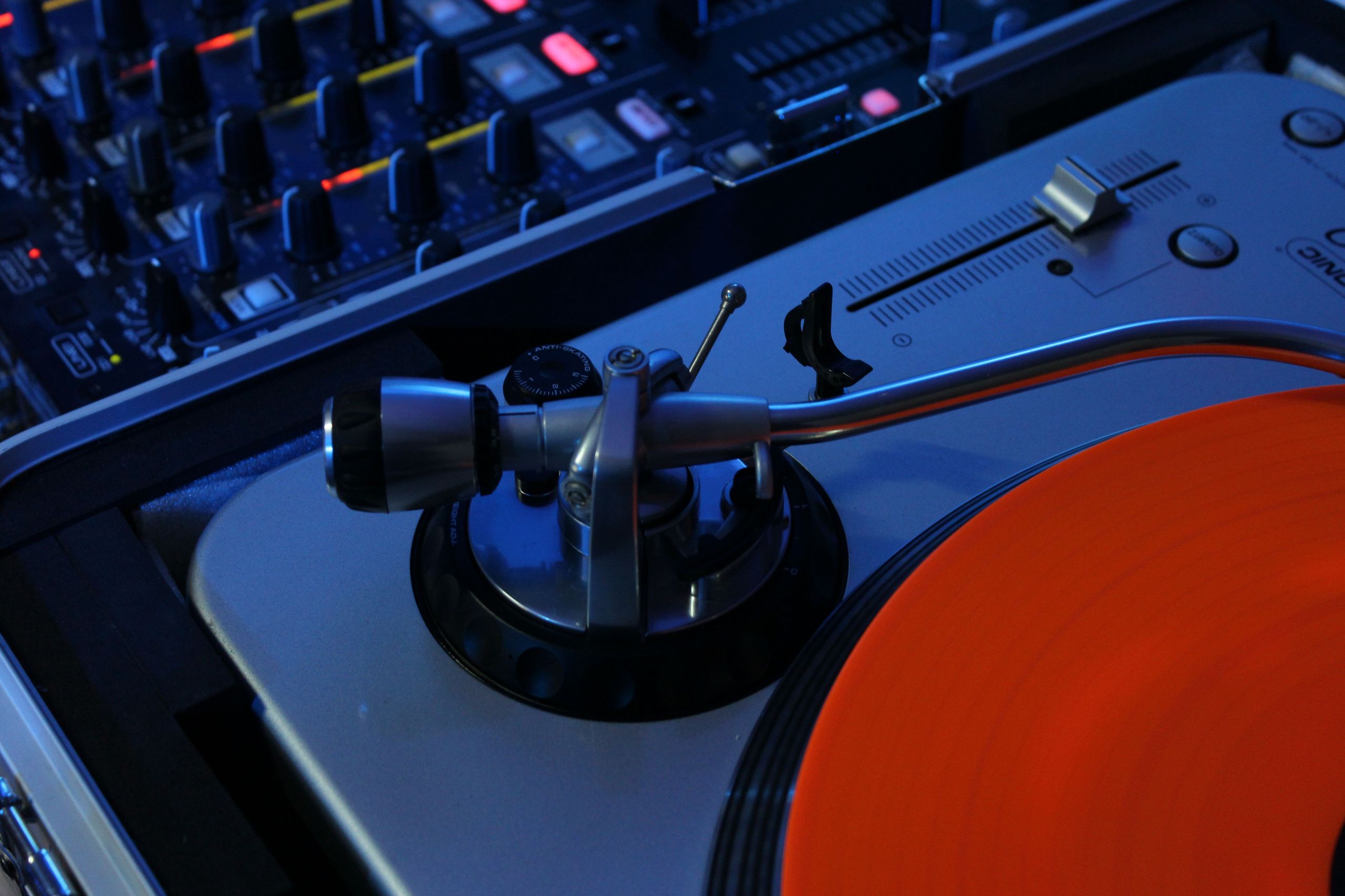 Close-up of a professional audio mixer with faders and knobs, representing the technology used in modern DJing and music production
